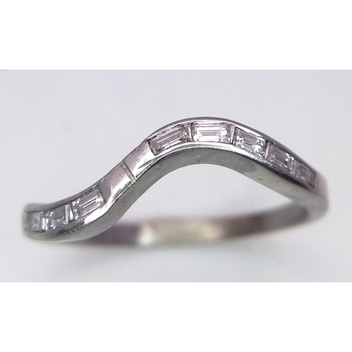 705 - A Platinum and Diamond Swirl Ring. 10 baguette cut diamonds. Size Q. 3.45g total weight.