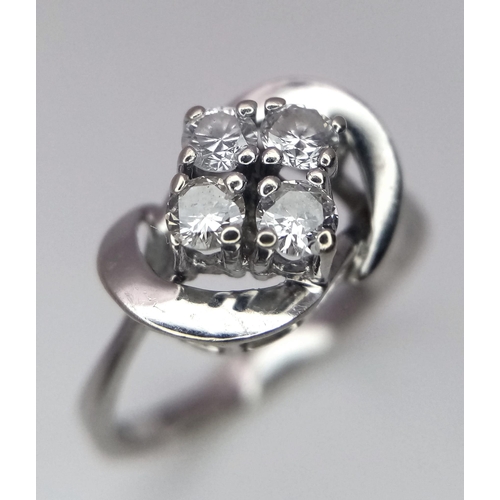 719 - An 18K White Gold Four Stone Diamond Ring. Four brilliant round cut diamonds in a swirl setting. 1ct... 