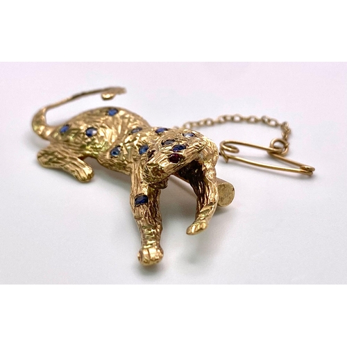 855 - A 9K Yellow Gold, Sapphire, Ruby and Diamond Decorative Panther Brooch - with safety chain. 5cm. 6.9... 