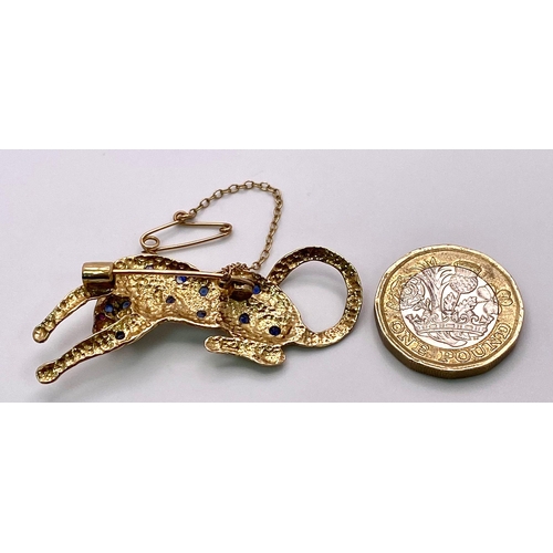 855 - A 9K Yellow Gold, Sapphire, Ruby and Diamond Decorative Panther Brooch - with safety chain. 5cm. 6.9... 