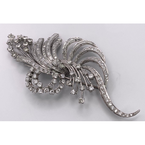 190 - An Art Deco Style Platinum and Diamond Brooch. A twisted foilage burst of 10ctw of VS clarity baguet... 