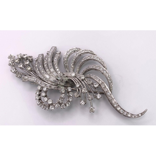 190 - An Art Deco Style Platinum and Diamond Brooch. A twisted foilage burst of 10ctw of VS clarity baguet... 