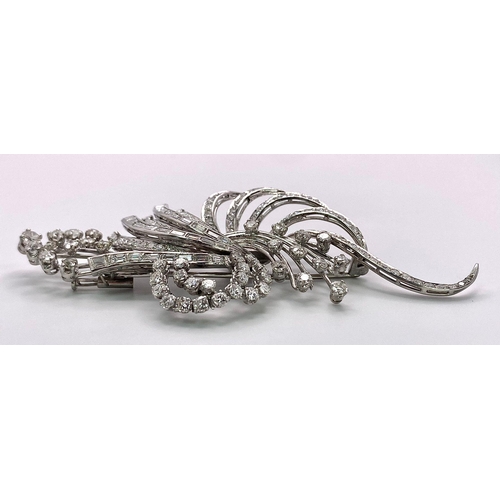 190 - An Art Deco Style Platinum and Diamond Brooch. A twisted foilage burst of 10ctw of VS clarity baguet... 