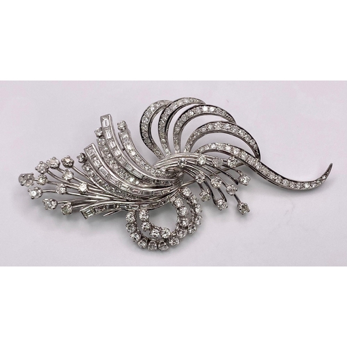 190 - An Art Deco Style Platinum and Diamond Brooch. A twisted foilage burst of 10ctw of VS clarity baguet... 