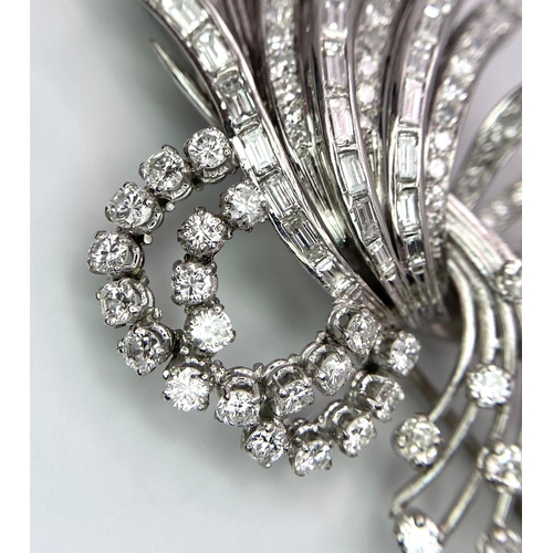 190 - An Art Deco Style Platinum and Diamond Brooch. A twisted foilage burst of 10ctw of VS clarity baguet... 