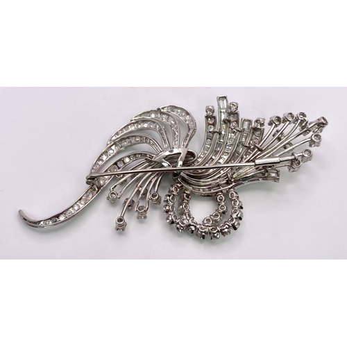 190 - An Art Deco Style Platinum and Diamond Brooch. A twisted foilage burst of 10ctw of VS clarity baguet... 