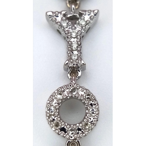 1290 - An 18K White Gold and Diamond Encrusted 'I Love You' Pendant. 4.5cm length. 3.4g total weight.