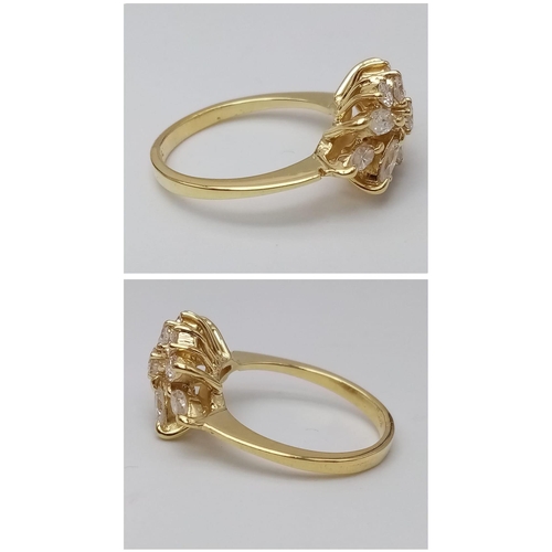 254 - An 18K Yellow Gold and Diamond Decorative Floral Ring. Central brilliant round cut diamond with marq... 