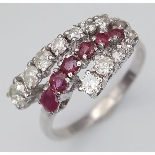 268 - An 18K White Gold Ruby and Diamond Crossover Ring. Six round cut rubies in-between two rows of round... 