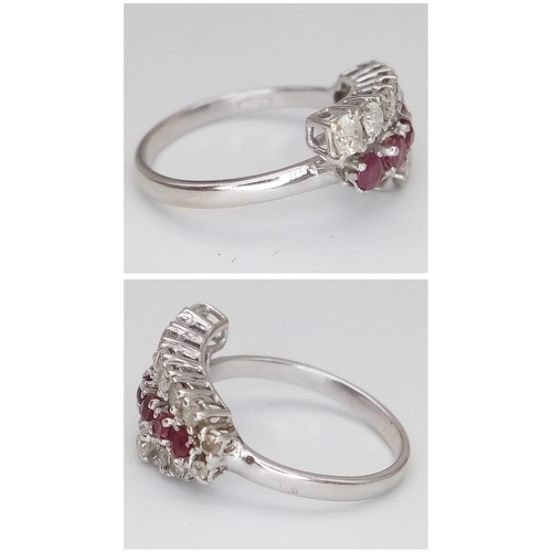 268 - An 18K White Gold Ruby and Diamond Crossover Ring. Six round cut rubies in-between two rows of round... 