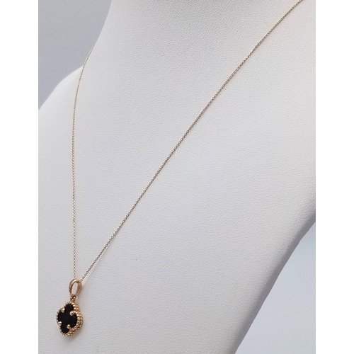 289 - An 18K Gold and Onyx Four Leaf Clover Pendant on a Disappearing 18K Gold Necklace. 17mm and 40cm. 2g... 