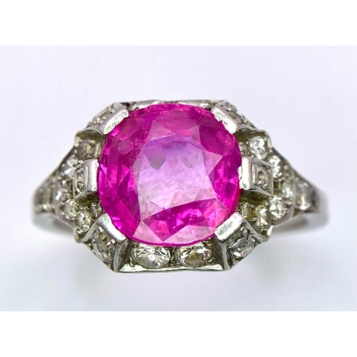 302 - A 9K White Gold Ruby and Diamond Ring. Central round-cut ruby with a diamond surround. Size M/N. 4.1... 