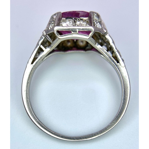 302 - A 9K White Gold Ruby and Diamond Ring. Central round-cut ruby with a diamond surround. Size M/N. 4.1... 