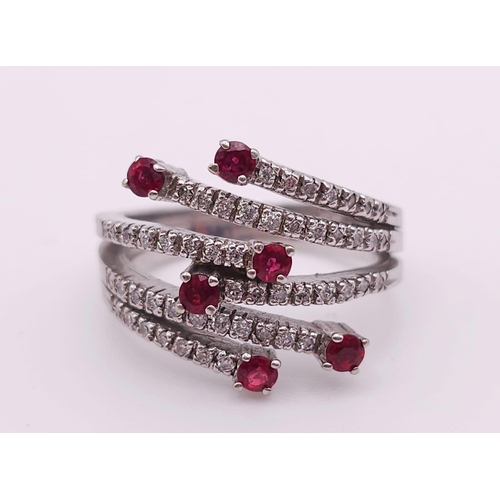 64 - An 18K White Gold, Ruby and Diamond Five-Stem Swirl Ring. 
Size M. 7.1g total weight.