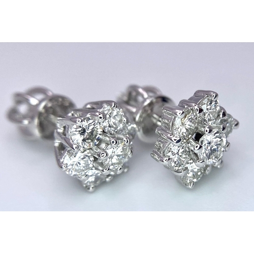 67 - A Pair of 18K White Gold Diamond Floral Stud Earrings. Seven bright round cut diamonds in each. 2.8g... 