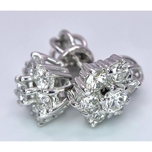 67 - A Pair of 18K White Gold Diamond Floral Stud Earrings. Seven bright round cut diamonds in each. 2.8g... 