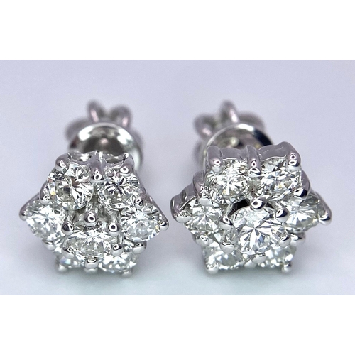 67 - A Pair of 18K White Gold Diamond Floral Stud Earrings. Seven bright round cut diamonds in each. 2.8g... 