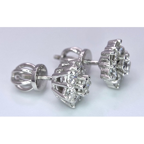 67 - A Pair of 18K White Gold Diamond Floral Stud Earrings. Seven bright round cut diamonds in each. 2.8g... 