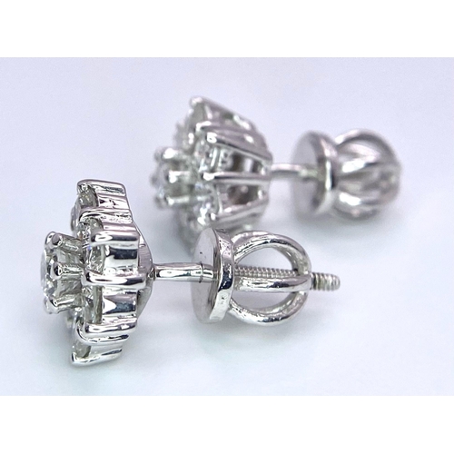 67 - A Pair of 18K White Gold Diamond Floral Stud Earrings. Seven bright round cut diamonds in each. 2.8g... 