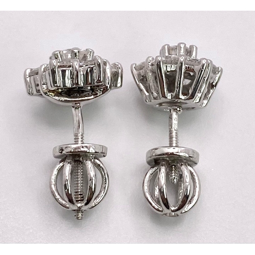 67 - A Pair of 18K White Gold Diamond Floral Stud Earrings. Seven bright round cut diamonds in each. 2.8g... 