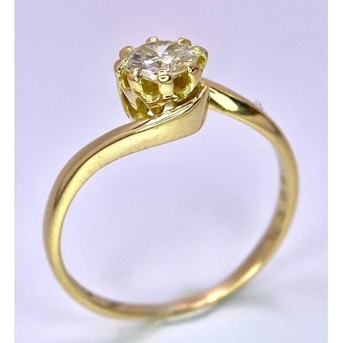 74 - An 18K Yellow Gold Diamond Crossover Ring. Brilliant round cut diamond, slight tint - 0.40ct. Size L... 