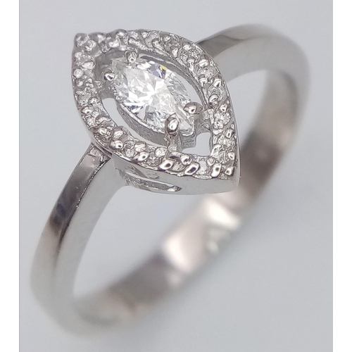 87 - An 18K White Gold and Marquise Cut Diamond Ring. Central bright marquise cut diamond with a round cu... 