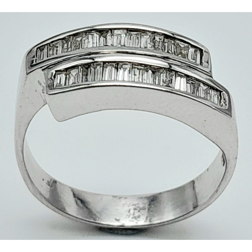 1339 - An 18K White Gold Diamond Crossover Ring. 24 small baguette cut diamonds in a crossover formation. S... 