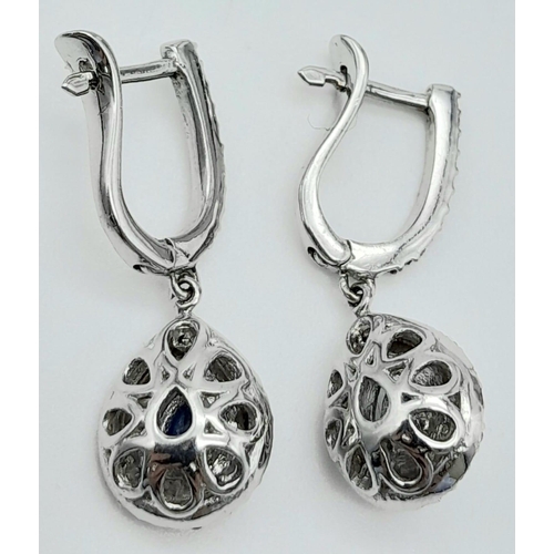 303 - A Pair of 18K White Gold Diamond and Sapphire Teardrop Earrings. Teardrop sapphires with teardrop di... 