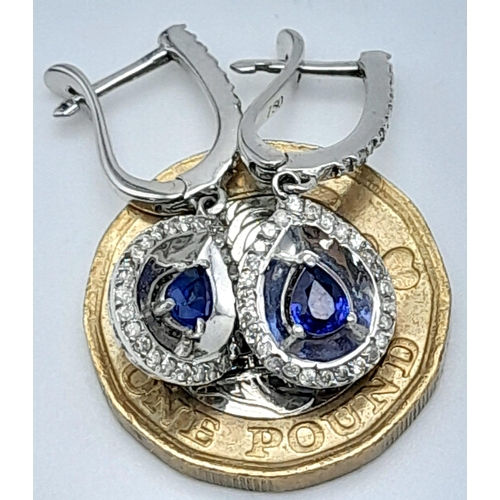 303 - A Pair of 18K White Gold Diamond and Sapphire Teardrop Earrings. Teardrop sapphires with teardrop di... 