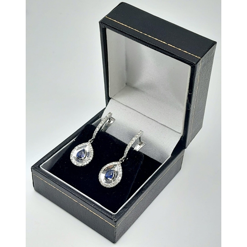 303 - A Pair of 18K White Gold Diamond and Sapphire Teardrop Earrings. Teardrop sapphires with teardrop di... 