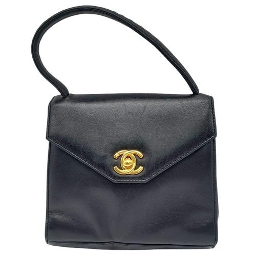 18 - A Vintage Chanel Black Handbag. Leather exterior with a single handle, gold toned hardware, the icon... 