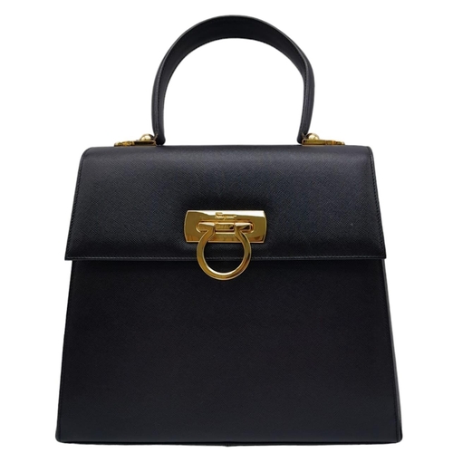 199 - A Salvatore Ferragamo Black Iconic Top Handle Bag. Leather exterior with gold toned hardware, 4 prot... 