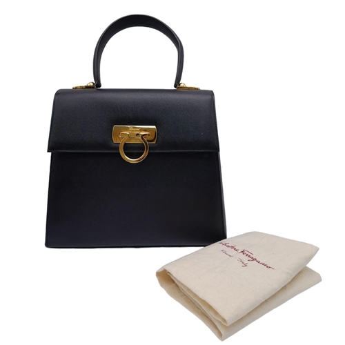 199 - A Salvatore Ferragamo Black Iconic Top Handle Bag. Leather exterior with gold toned hardware, 4 prot... 