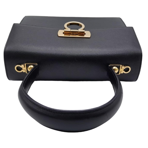 199 - A Salvatore Ferragamo Black Iconic Top Handle Bag. Leather exterior with gold toned hardware, 4 prot... 