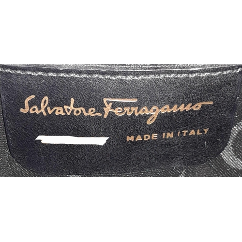 199 - A Salvatore Ferragamo Black Iconic Top Handle Bag. Leather exterior with gold toned hardware, 4 prot... 