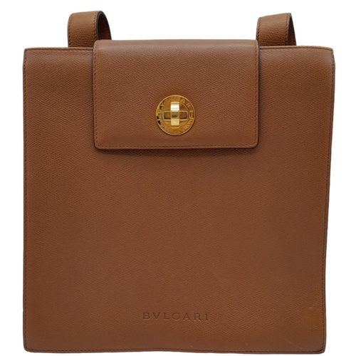 256 - A Bvlgari Tan Bag. Leather exterior with gold toned hardware, leather strap, flap and twist-clasp cl... 