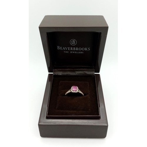 38 - A Beaverbrooks Pink Sapphire and Diamond Ring. Central gemstone with a diamond halo and accents. Siz... 