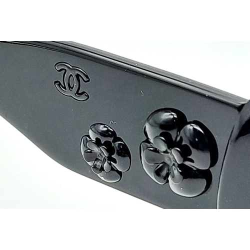 556 - Black Chanel Sunglasses with Floral Motifs. 
Built to be worn whilst driving a small convertible car... 