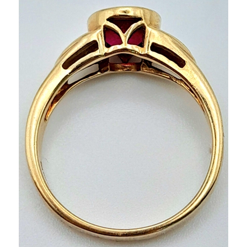 565 - A 9K YELLOW GOLD DIAMOND & RED STONE RING. Size N, 3.2g total weight.