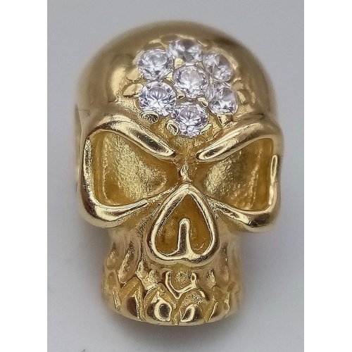 228 - A 14K YELLOW GOLD STONE SET SKULL PENDANT. 18mm length, 4.4g total weight.