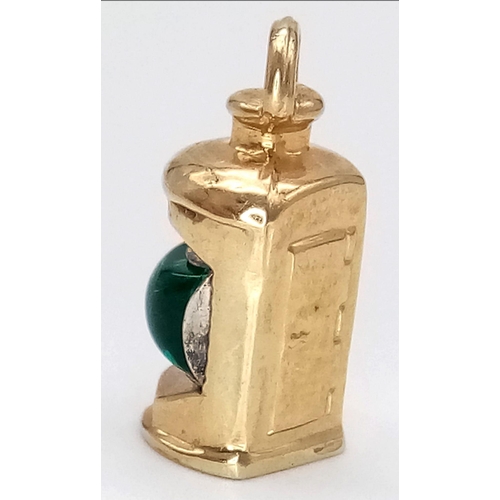 715 - A 9K YELLOW GOLD GREEN STONE SET LANTERN. 2cm length, 1.5g total weight.