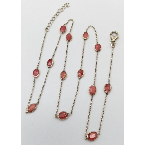 729 - A STERLING SILVER NECKLACE SET WITH 13 OVAL CUT RUBIES. 48cm length, 4.1g total weight.