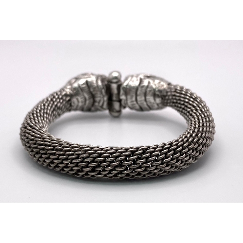 868 - A DOUBLE DRAGON HEAD SOLID SILVER BRACELET WITH SCREWING SAFETY FASTENING . 28.5gms