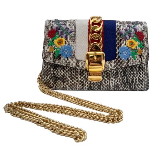 25 - Gucci Snakeskin Leather, Floral Embodied Bag.
This versatile bag can be carried as a clutch or a sho... 