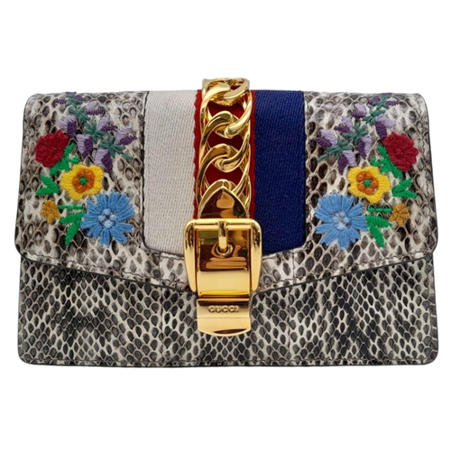 25 - Gucci Snakeskin Leather, Floral Embodied Bag.
This versatile bag can be carried as a clutch or a sho... 