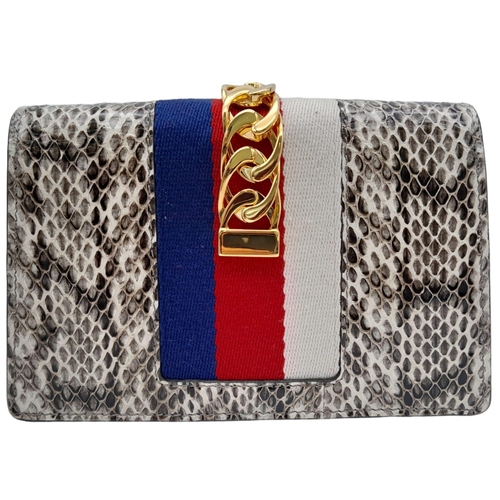 25 - Gucci Snakeskin Leather, Floral Embodied Bag.
This versatile bag can be carried as a clutch or a sho... 