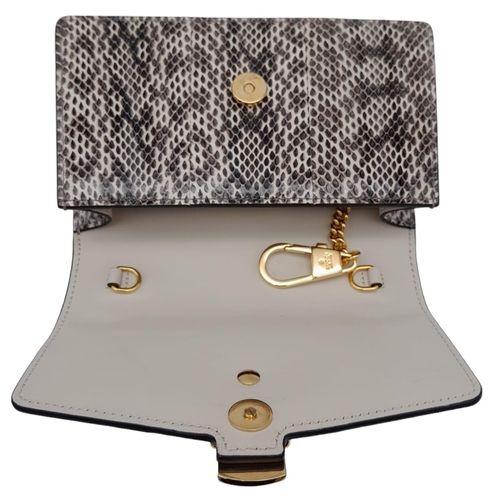 25 - Gucci Snakeskin Leather, Floral Embodied Bag.
This versatile bag can be carried as a clutch or a sho... 