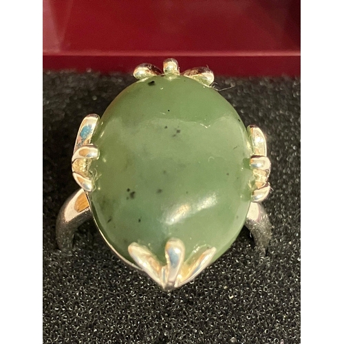 693 - SILVER and GREEN NEPHRITE RING. Consisting a large polished oval NEPHRITE Set in a Designer four cla... 