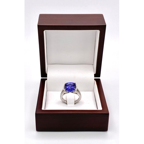 83 - A BESPOKE 18K WHITE GOLD TANZANITE & DIAMOND RING, SET WITH AAA QUALITY CUSHION CUT 6.17CT TANZANITE... 