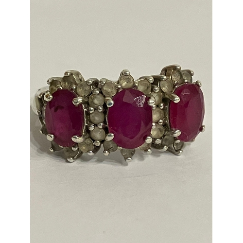 651 - Beautiful RUBY and TOPAZ RING. Consisting a Silver Ring Having three oval cut RUBIES set to top, eac... 